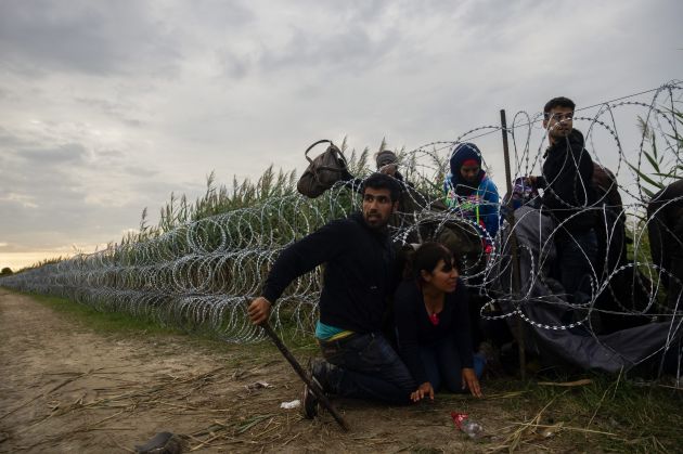 Menekültcsalád a kerítésnél